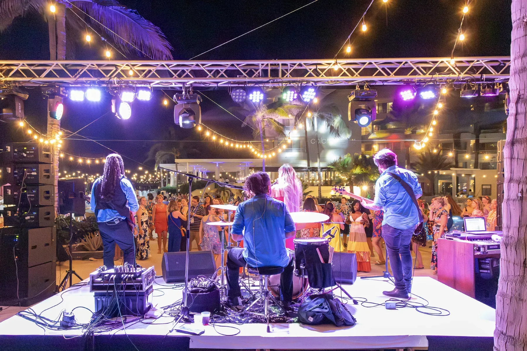 Live band on a lit truss stage at the Destination Color beach party