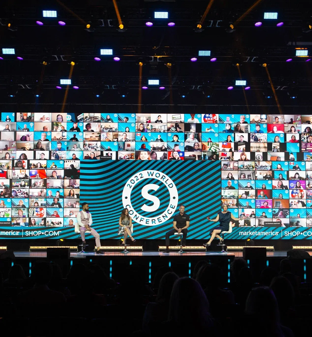 Four panelists seated before a 2022 World Conference logo and a large LED wall of virtual attendees