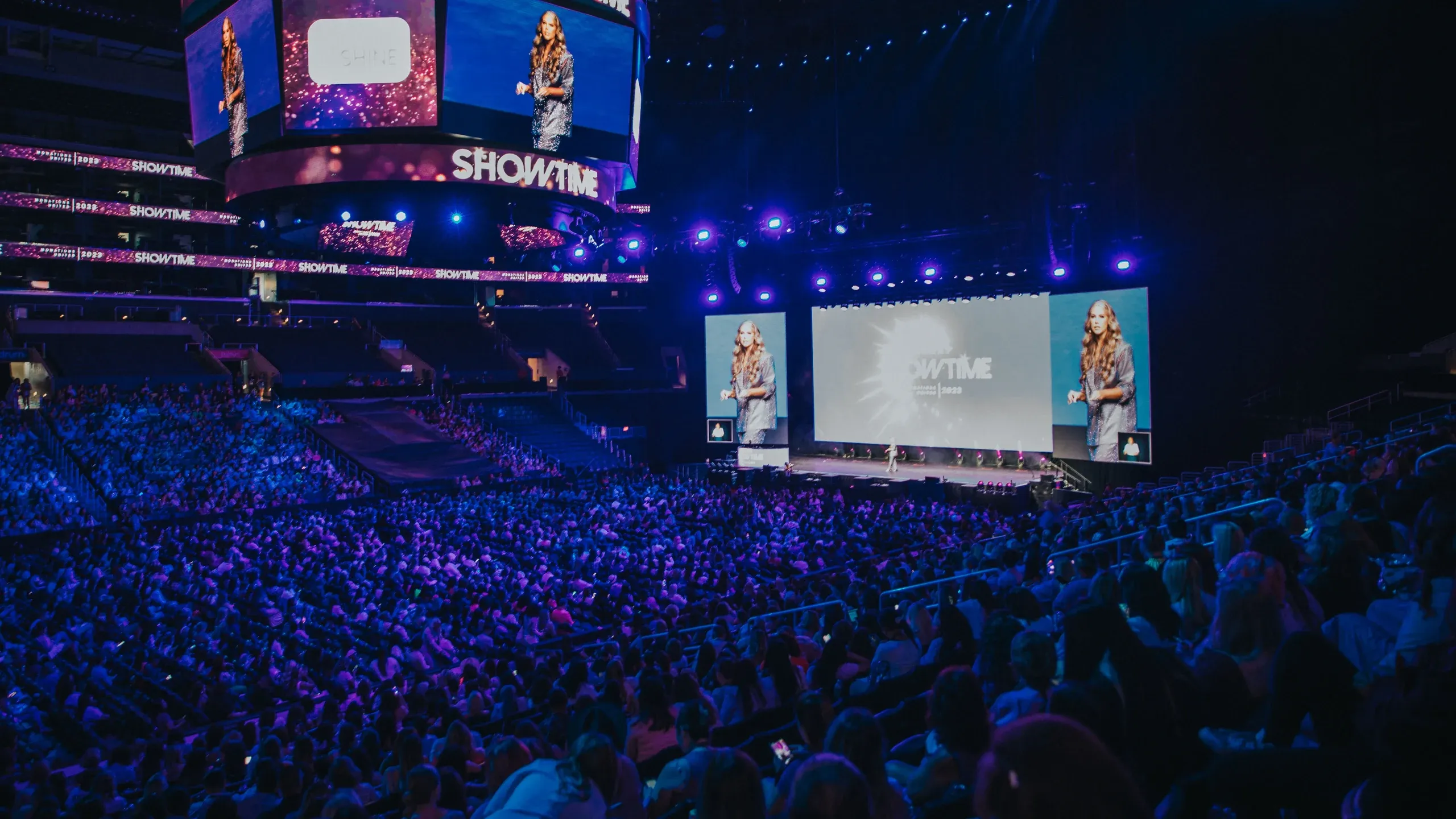 Packed arena watches a speaker on stage and on the SHOWTIME center-hung scoreboard and side screens